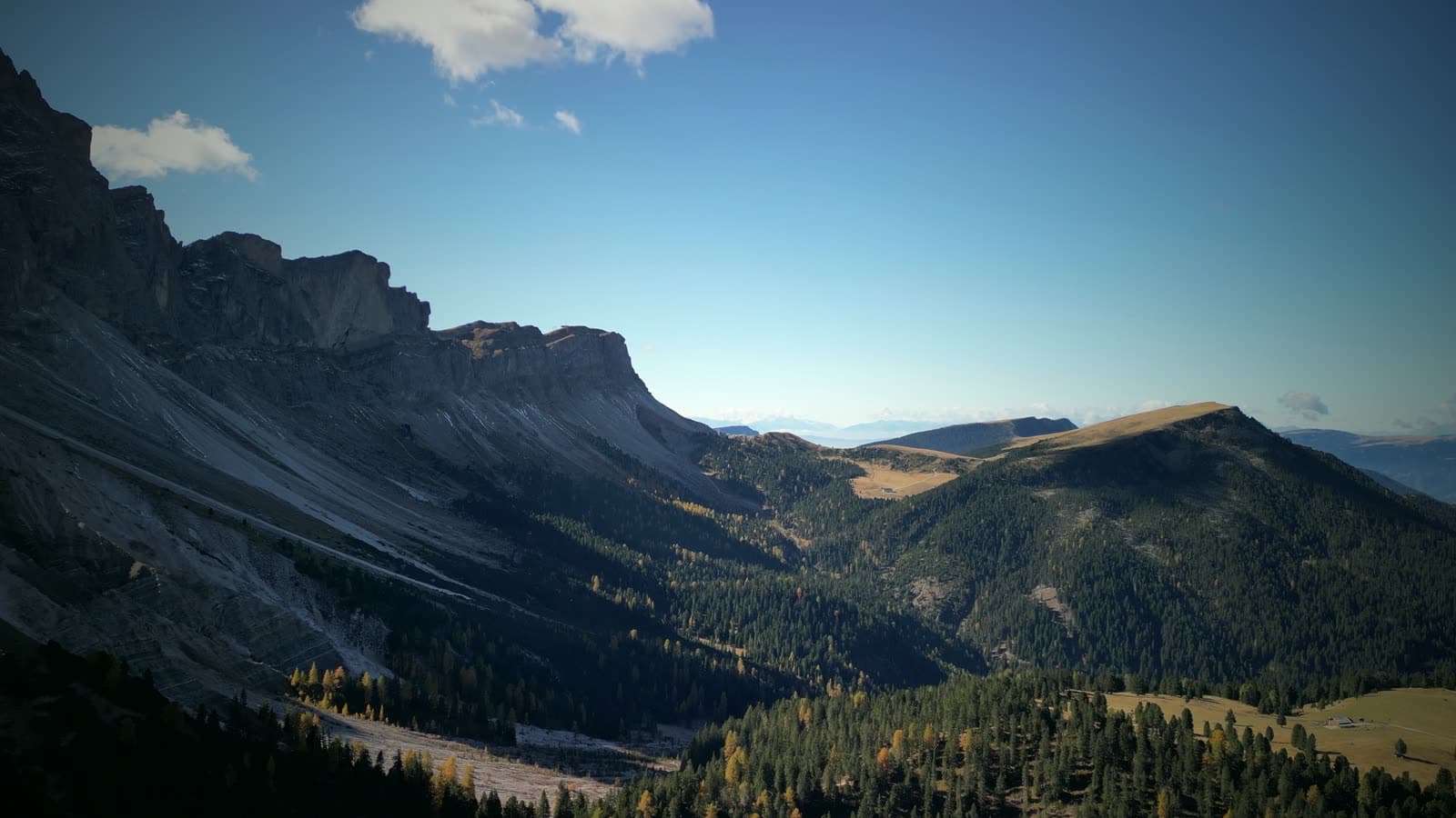 An aerial view of a valley in the Dolomites under a clear sky